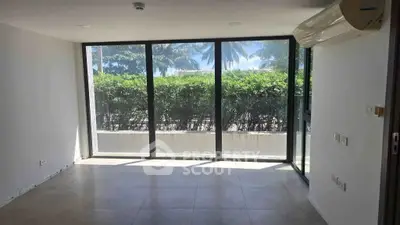 Bright living room with large windows and garden view, featuring modern air conditioning unit.