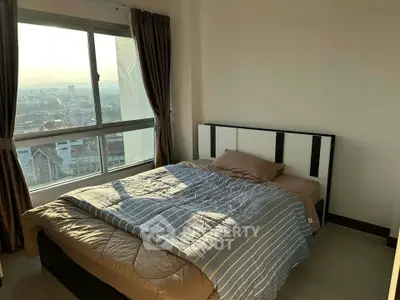 Cozy bedroom with large window offering stunning city view