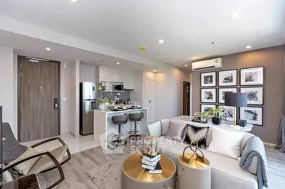 Modern open-plan living room with stylish decor and kitchen area in a contemporary apartment.