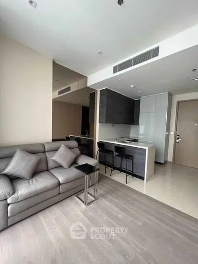 Modern open-layout living room with sleek kitchen and stylish furnishings