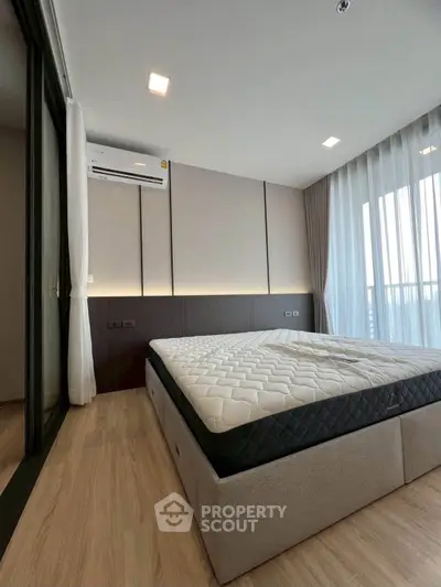 Modern bedroom with large window and minimalist design, featuring a comfortable bed and sleek flooring.