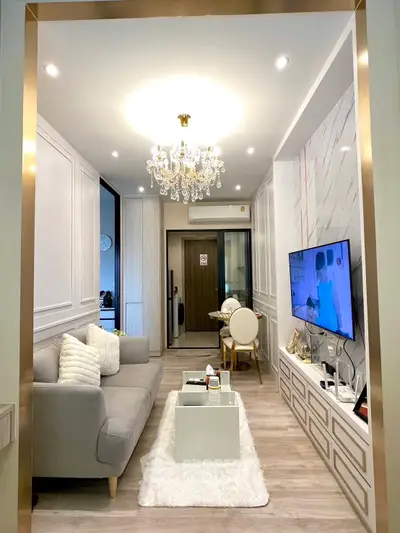 Elegant living room with chandelier, modern decor, and cozy seating area.