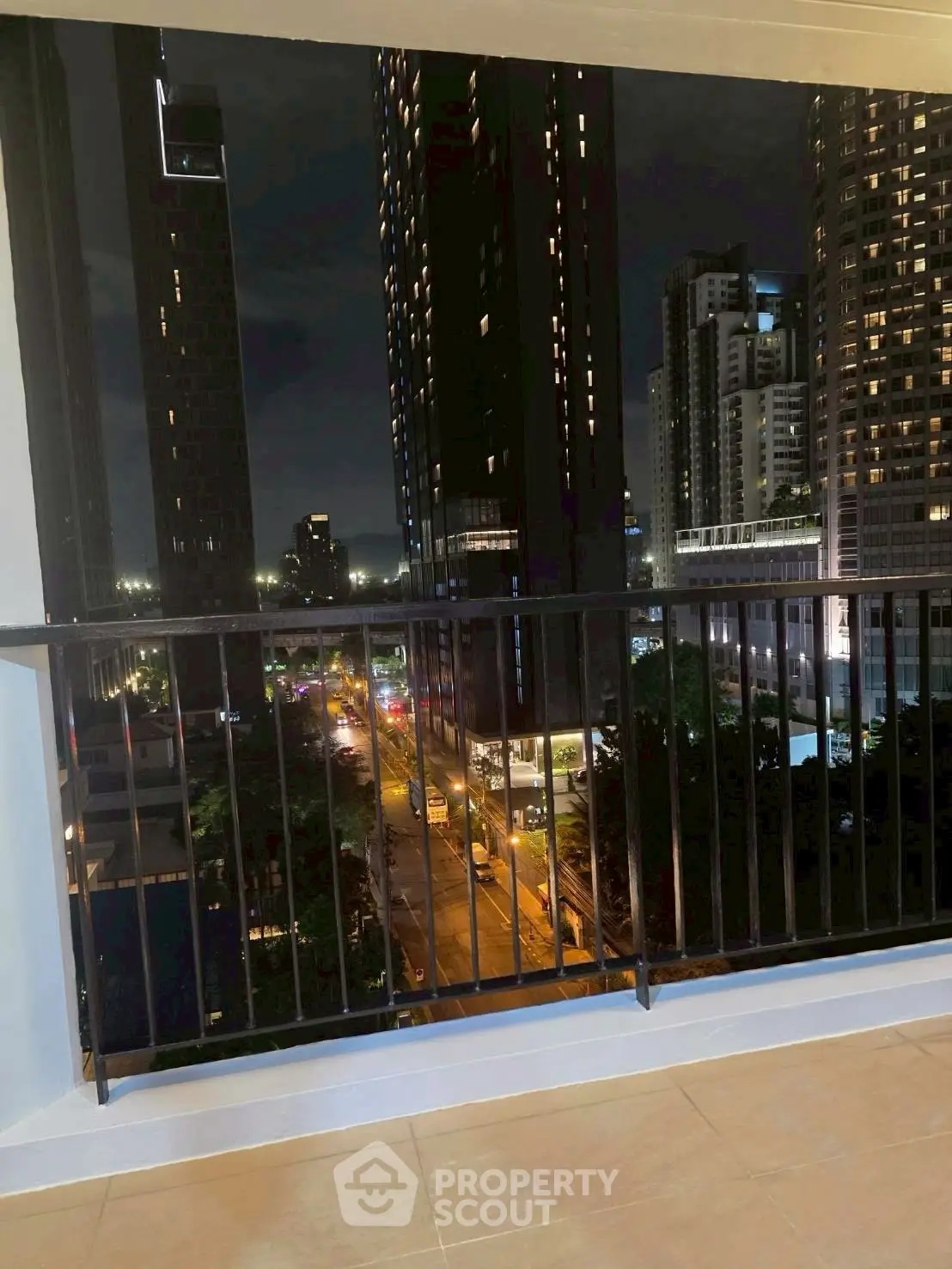Stunning cityscape view from a modern balcony at night, showcasing urban living.