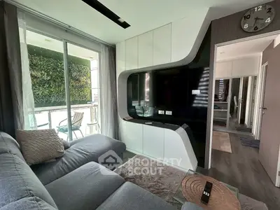 Modern living room with sleek TV unit and balcony view, featuring stylish decor and comfortable seating.