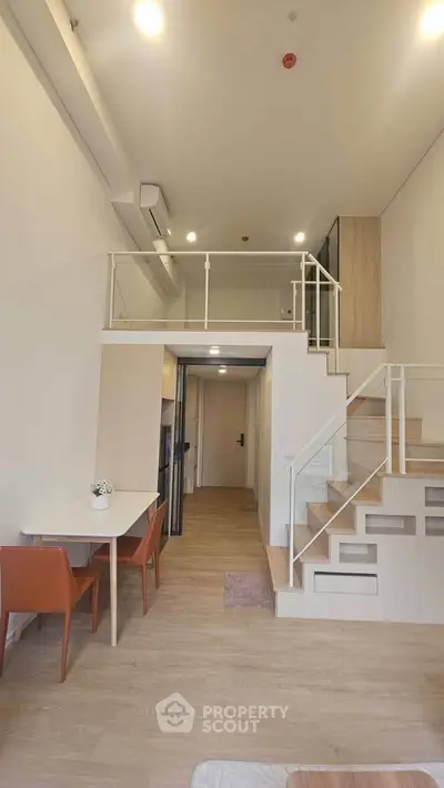 Modern loft apartment with stylish staircase and open layout, perfect for urban living.