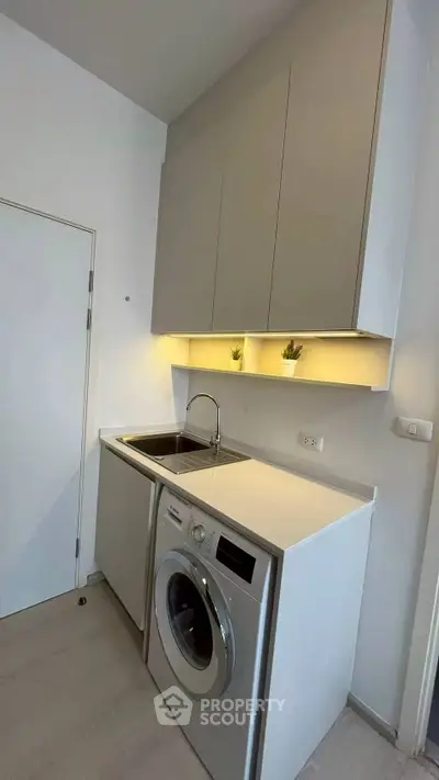 Modern kitchen with sleek cabinetry and built-in washing machine