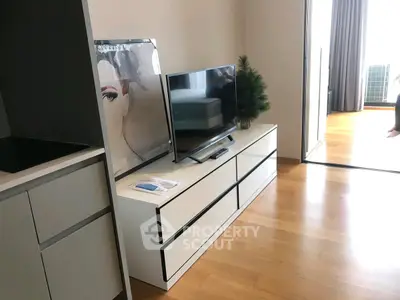 Modern living room with sleek TV stand and hardwood floors, featuring contemporary decor.