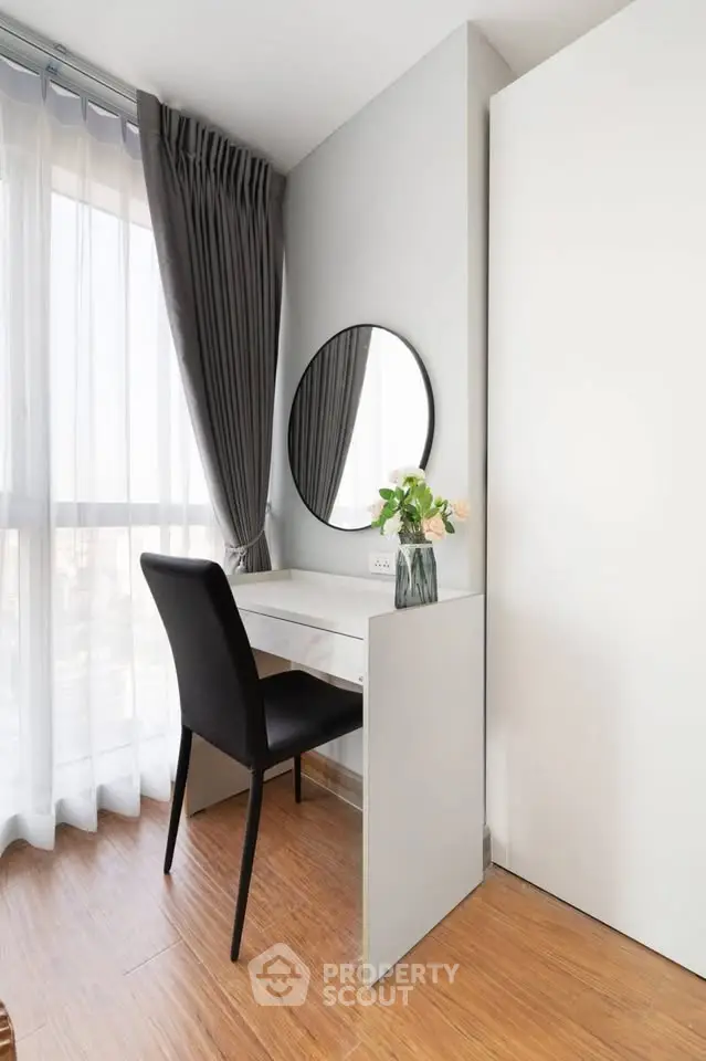 Modern study nook with sleek desk, chair, and round mirror by a large window with elegant curtains.