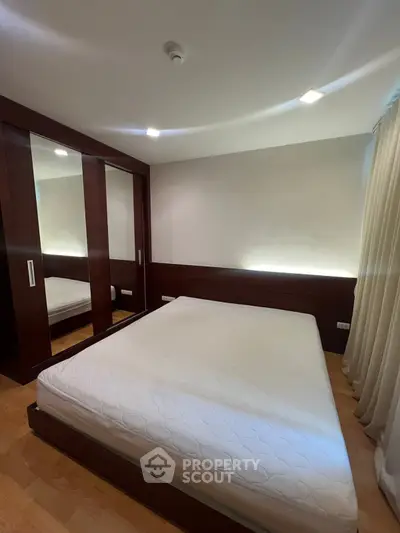 Modern bedroom with sleek wooden wardrobe and cozy lighting