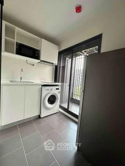 Modern compact kitchen with washing machine and balcony access