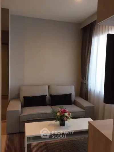 Cozy living room with modern sofa and elegant decor in a well-lit apartment.