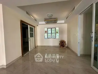 Spacious living room with marble flooring and decorative window accents
