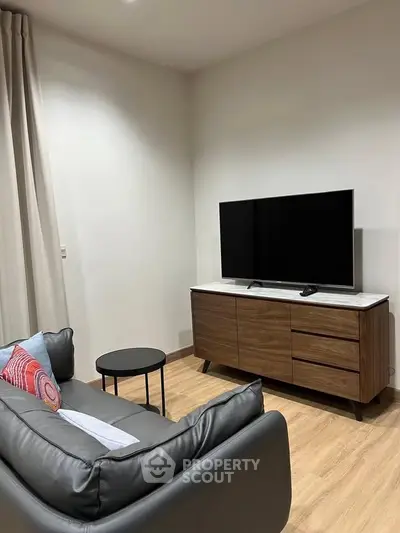 Modern living room with sleek TV stand and cozy sofa, perfect for relaxation.