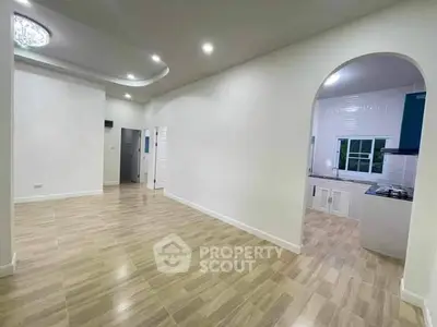 Spacious open-plan living area with modern kitchen and elegant flooring, perfect for family gatherings.