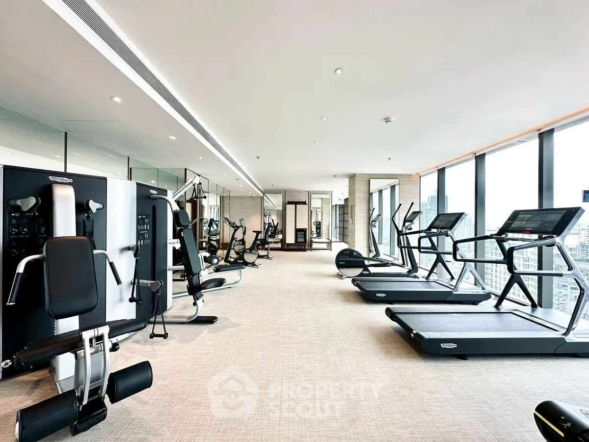 Luxurious high-rise gym with panoramic city views and modern fitness equipment.