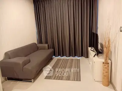 Modern living room with sleek sofa and TV, featuring elegant curtains and minimalist decor.
