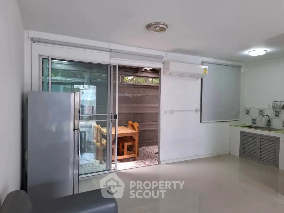Spacious living area with sliding glass doors leading to a cozy outdoor dining space.