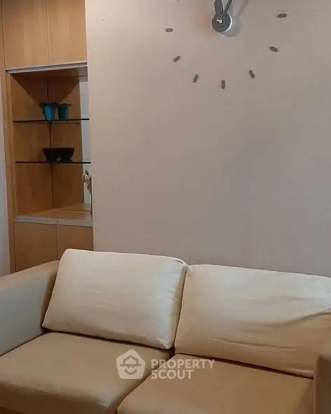 Modern living room with beige sofa and stylish wall clock