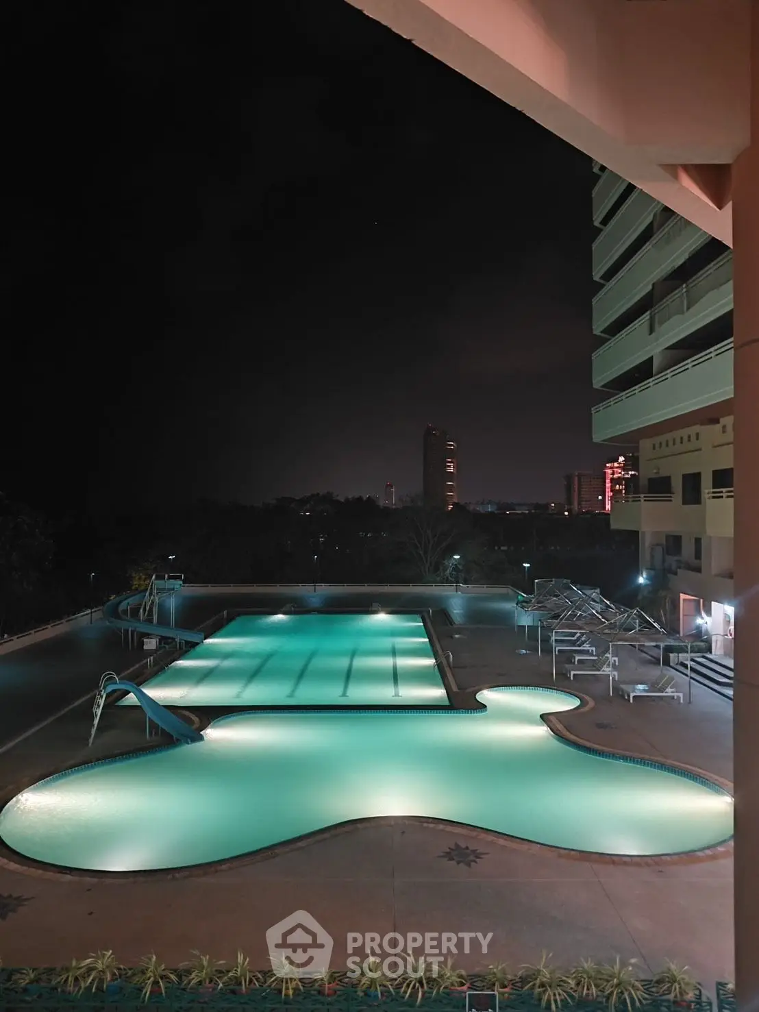 Luxurious night view of illuminated swimming pool in modern residential complex