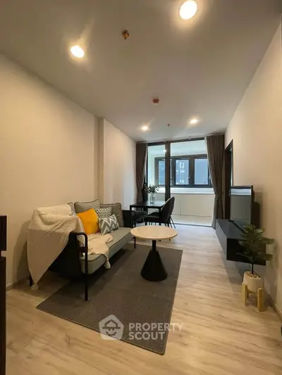 Modern living room with stylish decor and natural light, featuring cozy seating and elegant flooring.