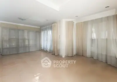 Spacious empty room with large windows and elegant curtains