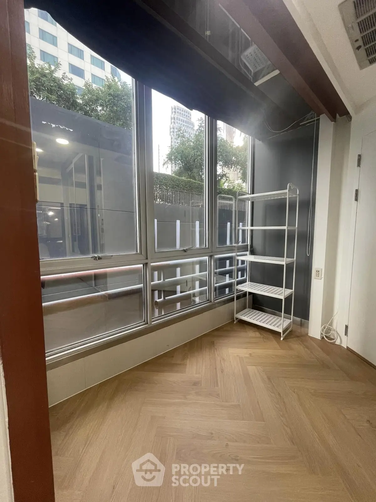 Bright room with large windows and wooden flooring, ideal for versatile use.