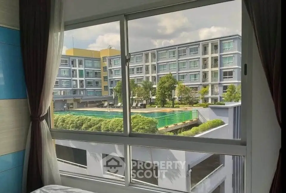 Modern apartment view with pool and greenery from window