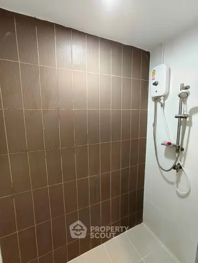 Modern bathroom with sleek shower and brown tiled wall