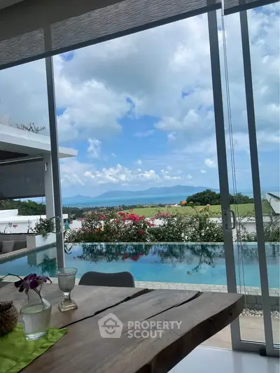 Luxurious open-plan living room with stunning ocean view and infinity pool, perfect for relaxation and entertaining.