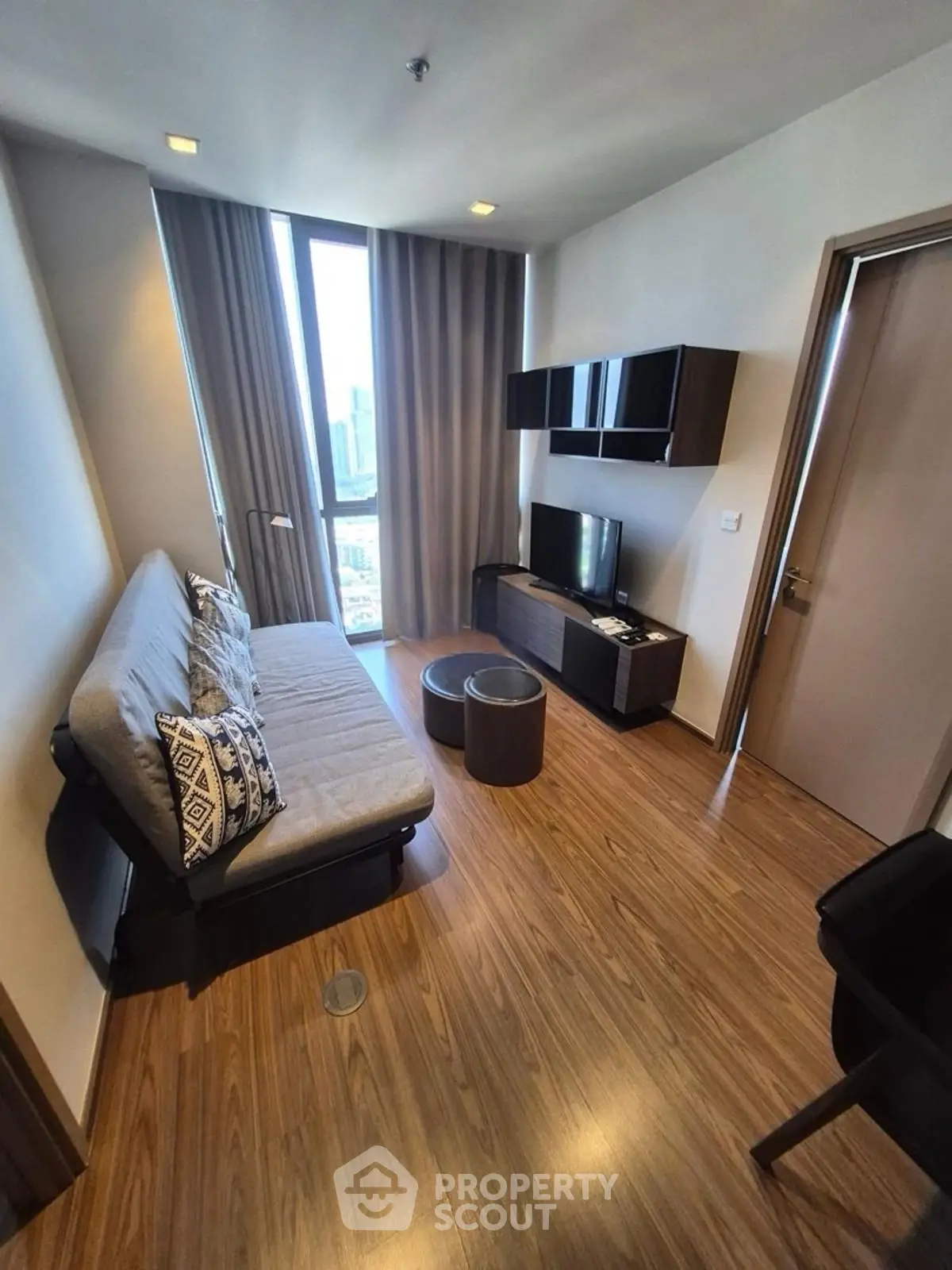 Modern living room with sleek furniture and city view, perfect for urban living.