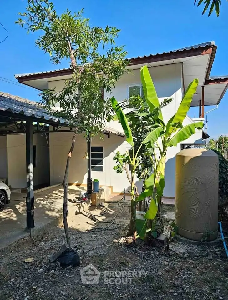 Charming two-story house with lush garden and carport, perfect for family living.