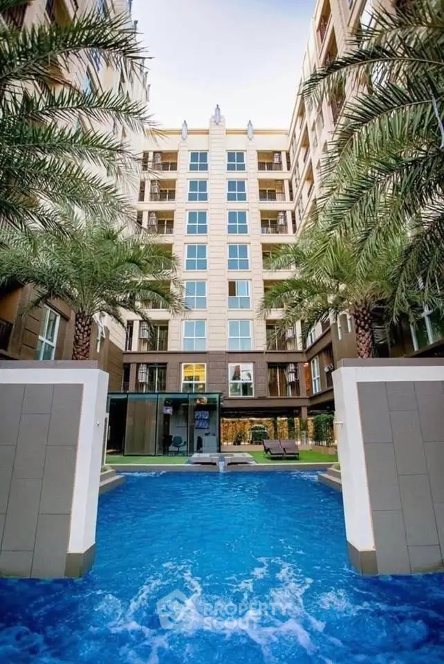 Luxurious apartment building with stunning pool and palm trees, perfect for resort-style living.