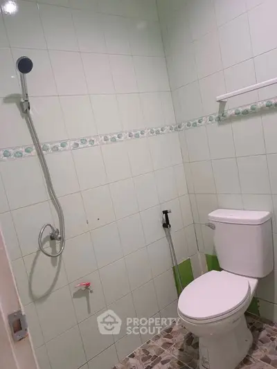 Compact bathroom with tiled walls and modern fixtures, ideal for small spaces.