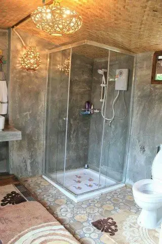 Charming rustic bathroom with glass shower and unique lighting fixtures.