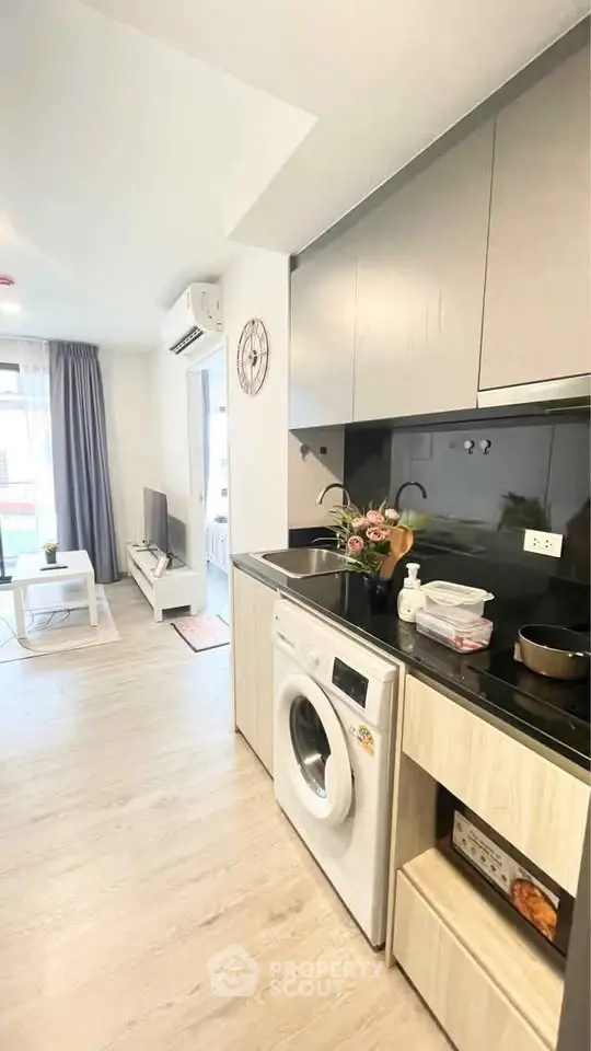 Modern kitchen with washing machine and open layout in stylish apartment