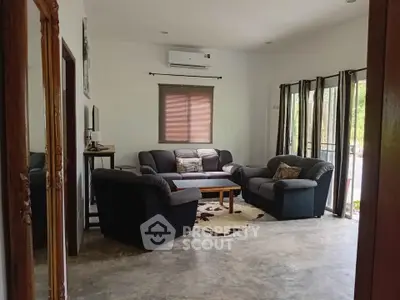 Spacious living room with cozy sofas and natural light, perfect for relaxation and entertaining guests.