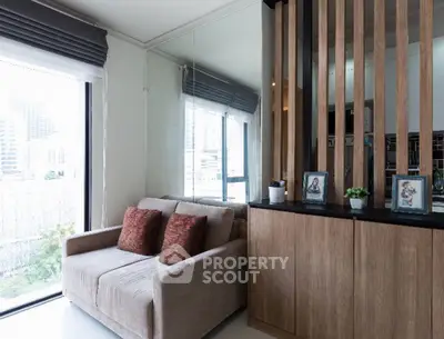 Modern living room with cozy sofa and large window offering city view