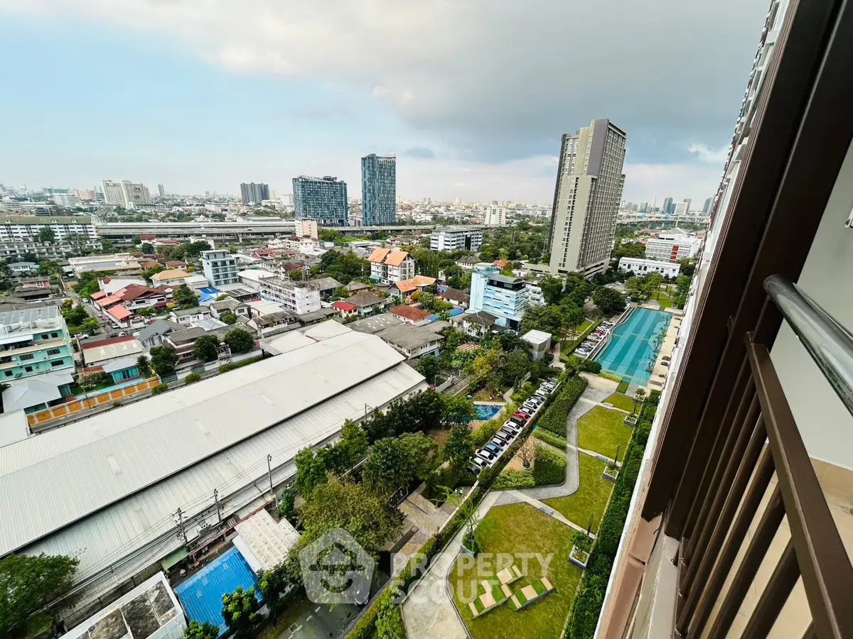 Stunning cityscape view from high-rise balcony overlooking urban landscape and lush gardens.