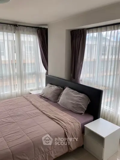 Cozy bedroom with large windows and modern decor in urban apartment