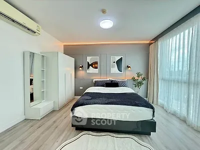 Spacious modern bedroom with elegant decor and large windows