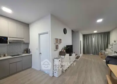 Modern open-plan living room and kitchen with sleek design and natural light.
