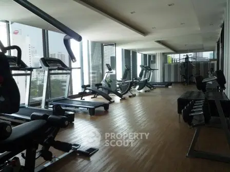 Spacious modern gym with city view in luxury apartment building