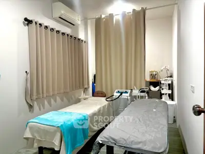 Modern treatment room with massage tables and soft lighting, ideal for wellness or spa services.