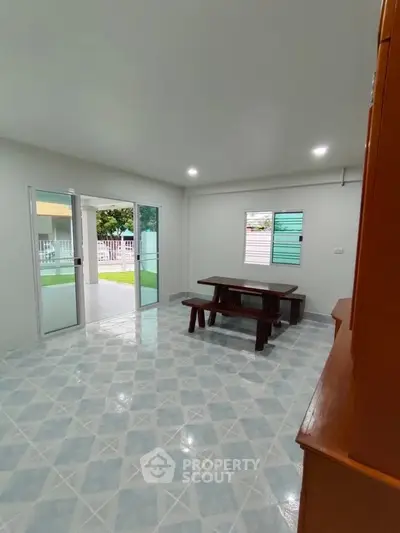 Spacious living room with tiled floor and sliding glass doors to patio.