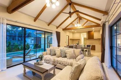Luxurious living room with vaulted ceilings and pool view, perfect for relaxation and entertaining.