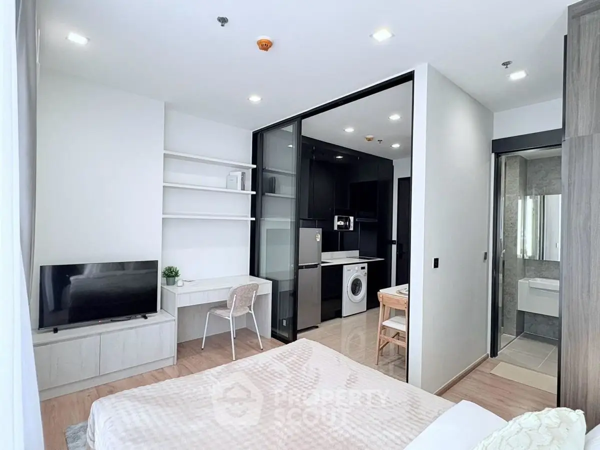 Modern studio apartment with open layout, featuring a compact kitchen and cozy living area.