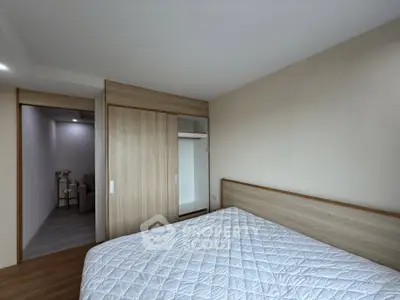 Spacious bedroom with modern wooden wardrobe and cozy bed in a minimalist design.