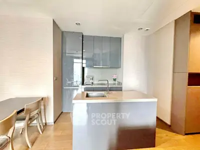 Modern kitchen with sleek cabinetry and island in open layout apartment