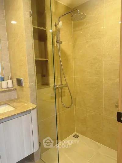 Modern bathroom with glass shower and elegant beige tiles