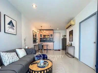 Modern living room with stylish decor and open layout, featuring cozy seating and elegant lighting.